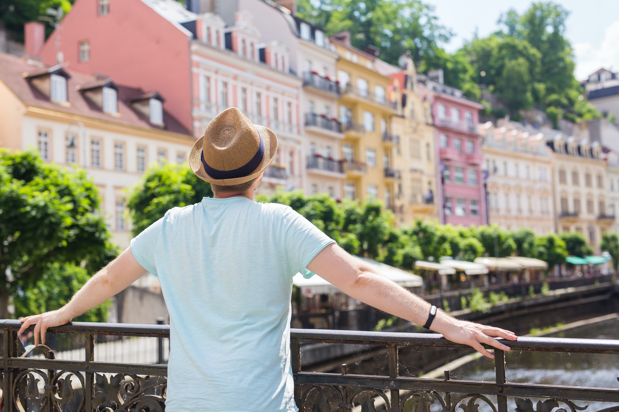 Back view of happy stylish tourist on Czech Republic. Handsome man travelling in Europe.