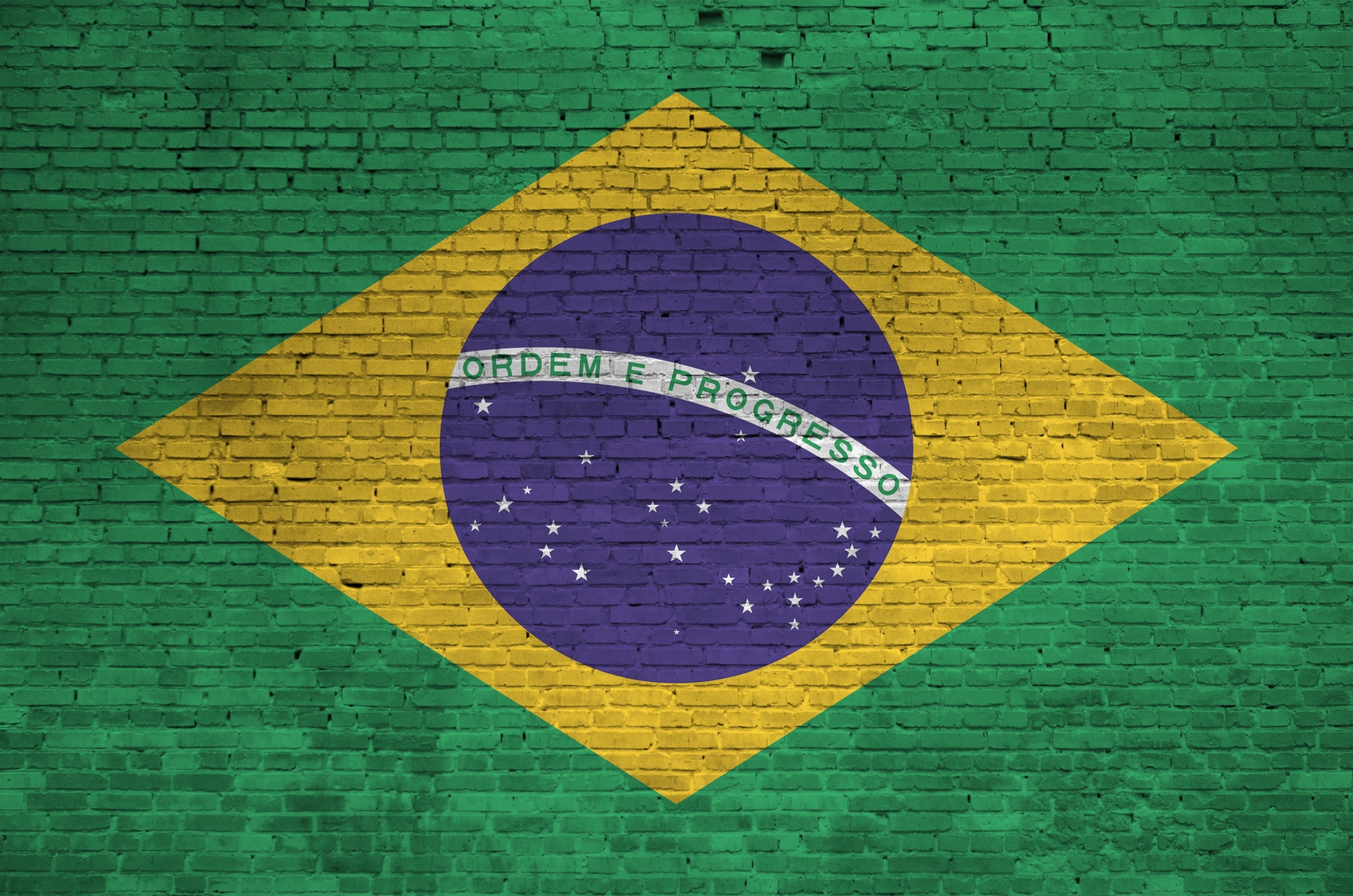 Brazil flag depicted in paint colors on old brick wall close up