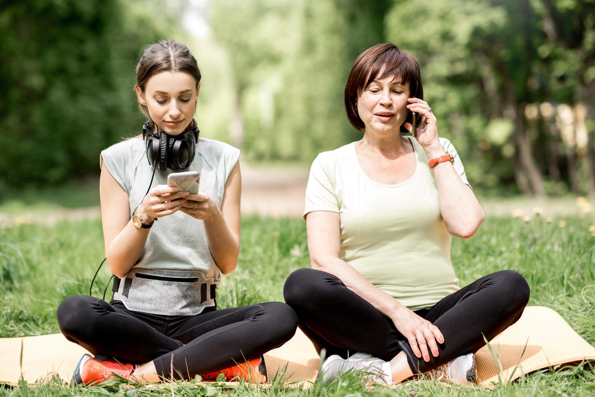 Young and elder woman doing yoga in the park
