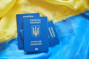 Three Ukrainian biometric passports on the flag of Ukraine, immigration because war